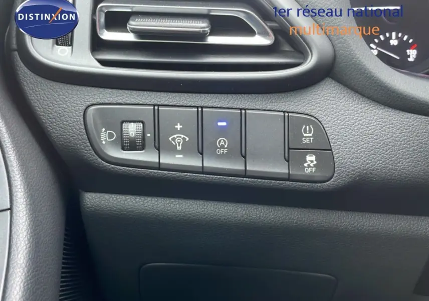 Détail du tableau de bord côté gauche avec commandes d'éclairage et aides à la conduite sur Hyundai i30 SW blanc.
