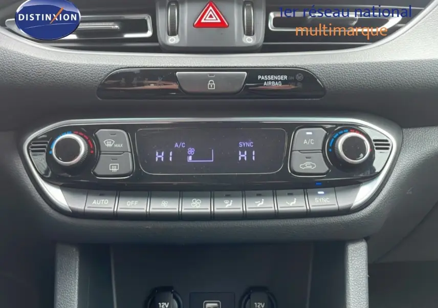 Gros plan sur la console centrale de la Hyundai i30 SW 2023, montrant les commandes de climatisation et ports USB/12V.