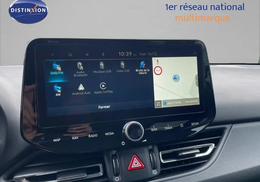 Écran tactile central de la Hyundai i30 SW 2023 affichant navigation et options multimédia, intérieur gris.