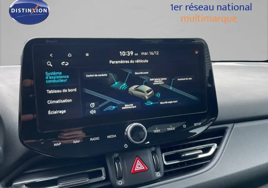 Écran tactile central du tableau de bord de la Hyundai i30 SW blanc Atlas, affichant les paramètres d’assistance conducteur.