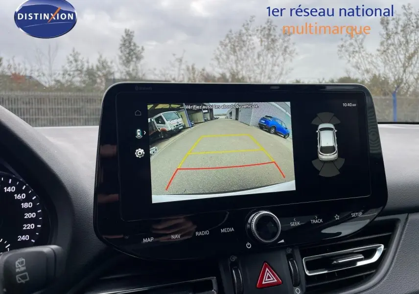 Écran central affichant la caméra de recul avec vue arrière du véhicule, tableau de bord noir moderne Hyundai i30 SW.