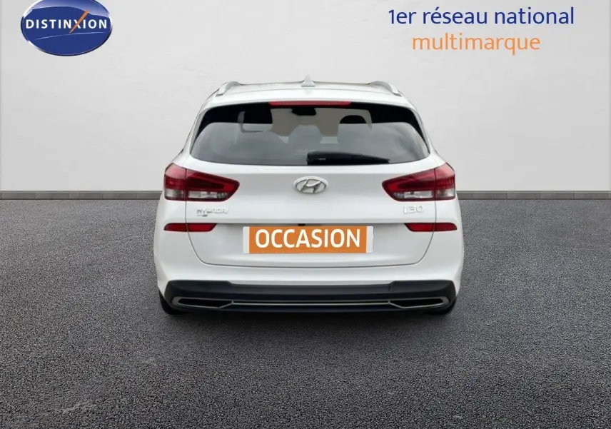 Vue arrière d'une Hyundai i30 SW blanche Atlas 2023 avec feux arrière LED et plaque "OCCASION".