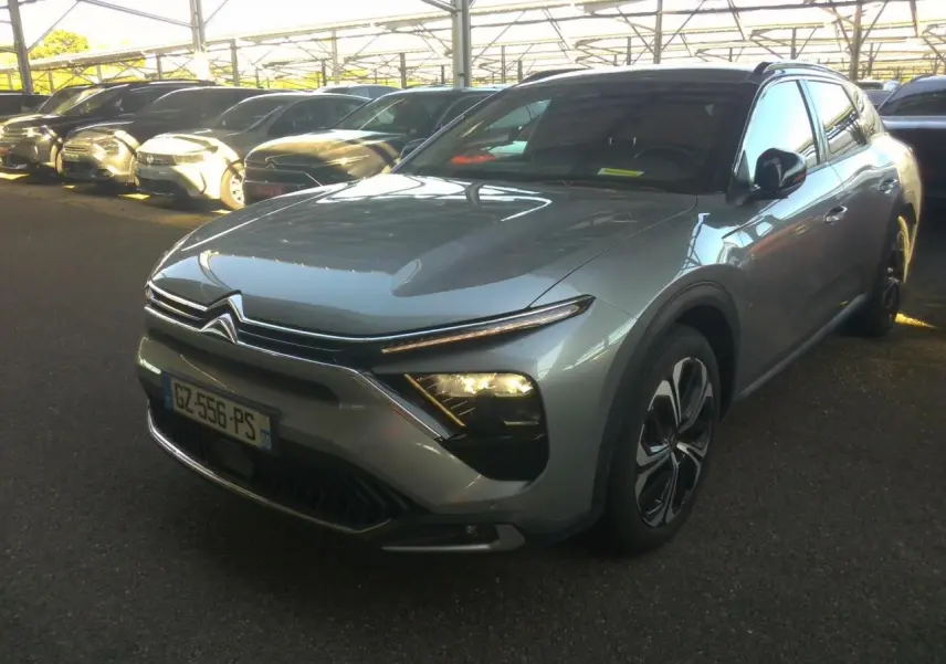Citroën C5 X gris foncé vue 3/4 avant droit avec feux allumés et calandre distinctive, année 2024.
