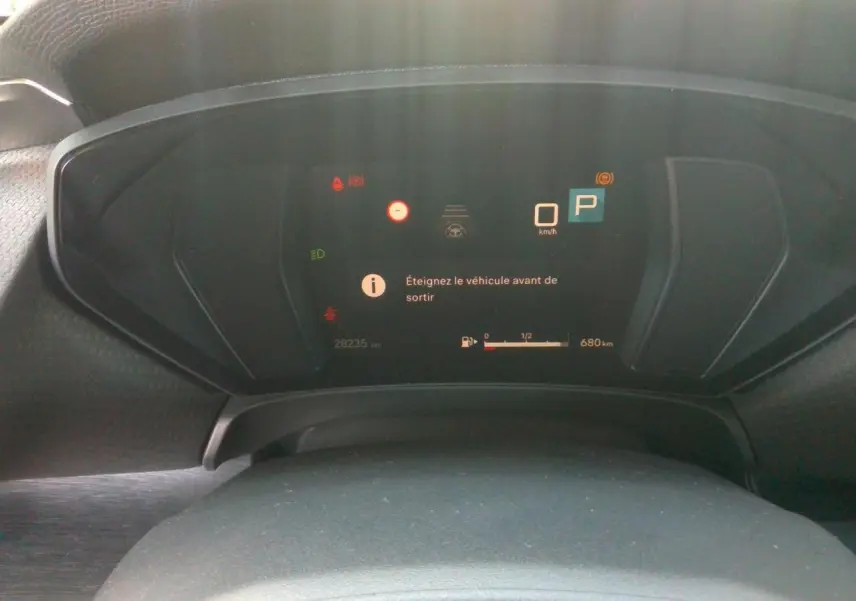 Tableau de bord numérique du Citroën C5 X 2024, affichage en veille avec message d'arrêt et jauge de carburant.