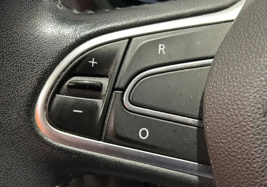Gros plan sur les commandes de régulateur de vitesse au volant du Renault Kadjar blanc, version TCE 130 ENERGY INTENS EDC.