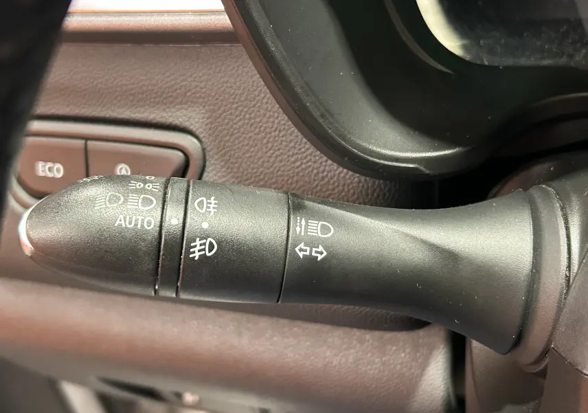 Gros plan sur la manette de commande des phares et clignotants du Renault Kadjar blanc, intérieur brun.