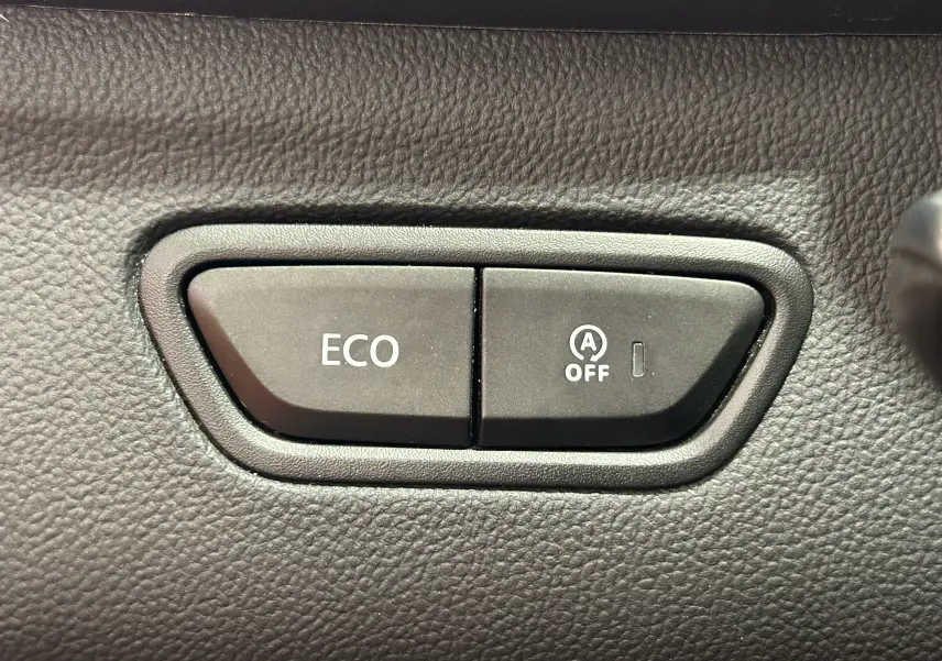 Boutons de commande ECO et désactivation du système start-stop sur le tableau de bord du Renault Kadjar blanc.