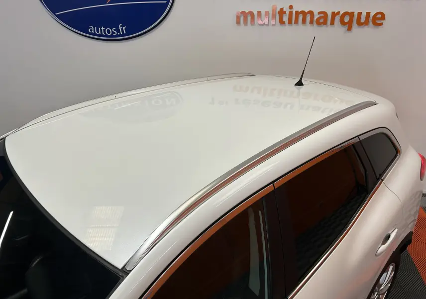 Vue plongeante sur le toit blanc et les vitres teintées du Renault Kadjar TCE 130 Energy Intens 2018 en intérieur showroom.