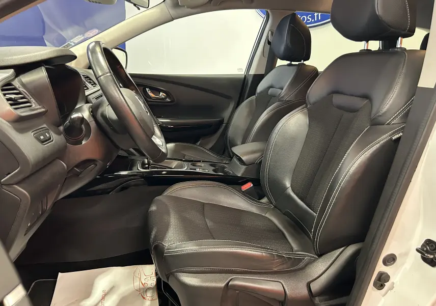 Vue intérieure côté conducteur du Renault Kadjar blanc 2018, sièges cuir noirs et tableau de bord moderne.
