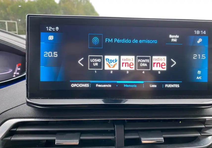 Vue rapprochée de l'écran tactile central du Peugeot 3008 gris platinium, affichant les options radio et climatisation.