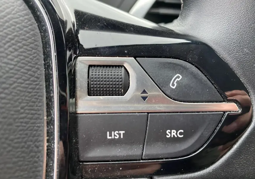 Gros plan sur les commandes noires du volant du Peugeot 3008 2021, avec boutons LIST, SRC et téléphone.