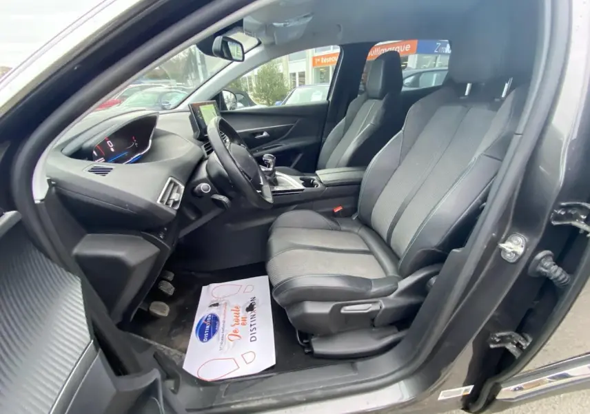 Intérieur avant droit d’un Peugeot 3008 gris platinium 2021, montrant sièges, volant compact et tableau de bord numérique.