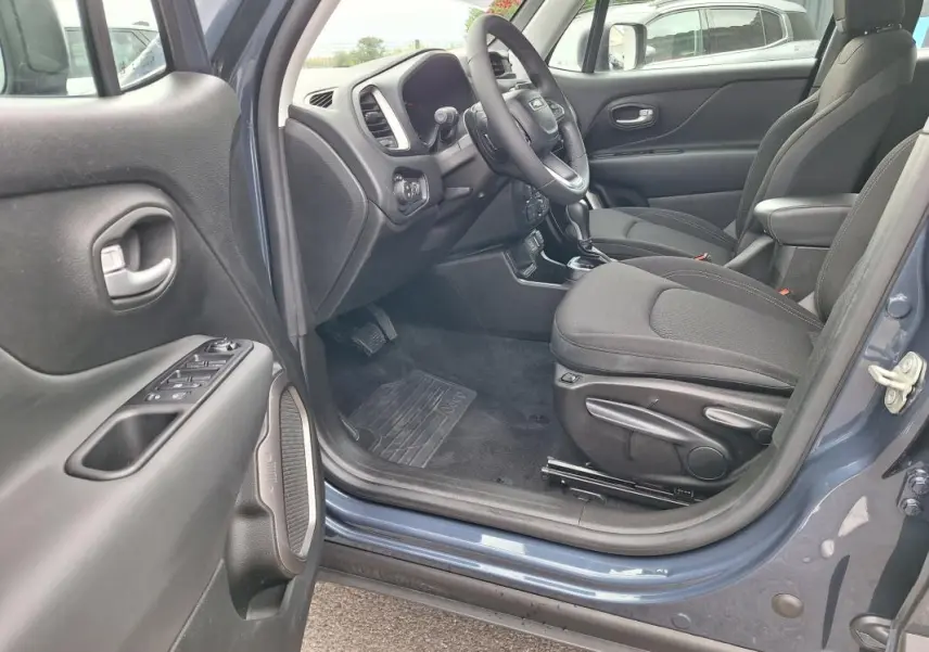 Vue intérieure côté conducteur du Jeep Renegade bleu 2024, montrant siège, volant et tableau de bord.