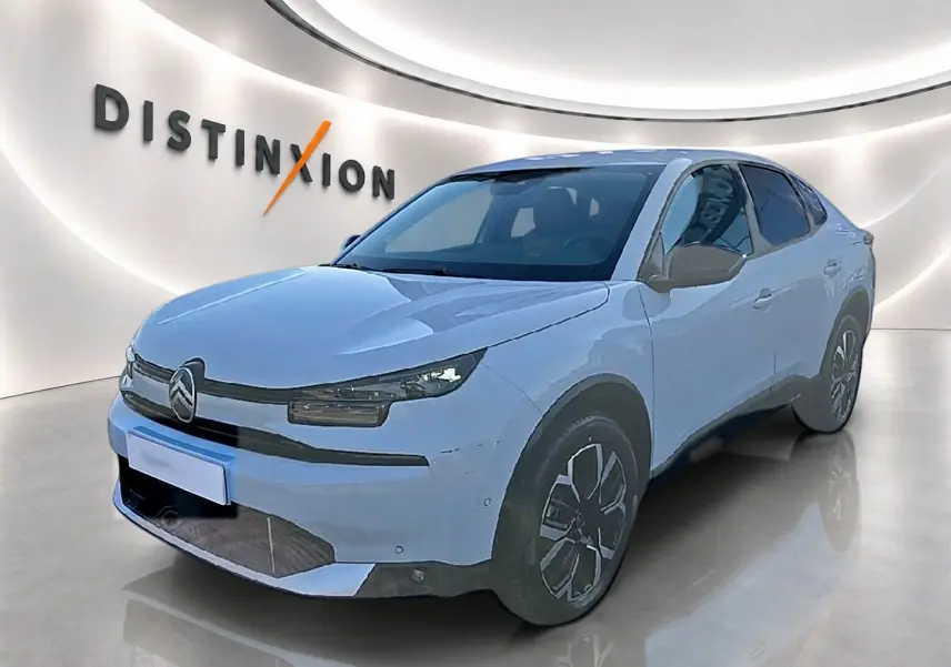 Citroën C4 X blanche vue 3/4 avant droit, avec jantes alu et phares LED dans un showroom lumineux.