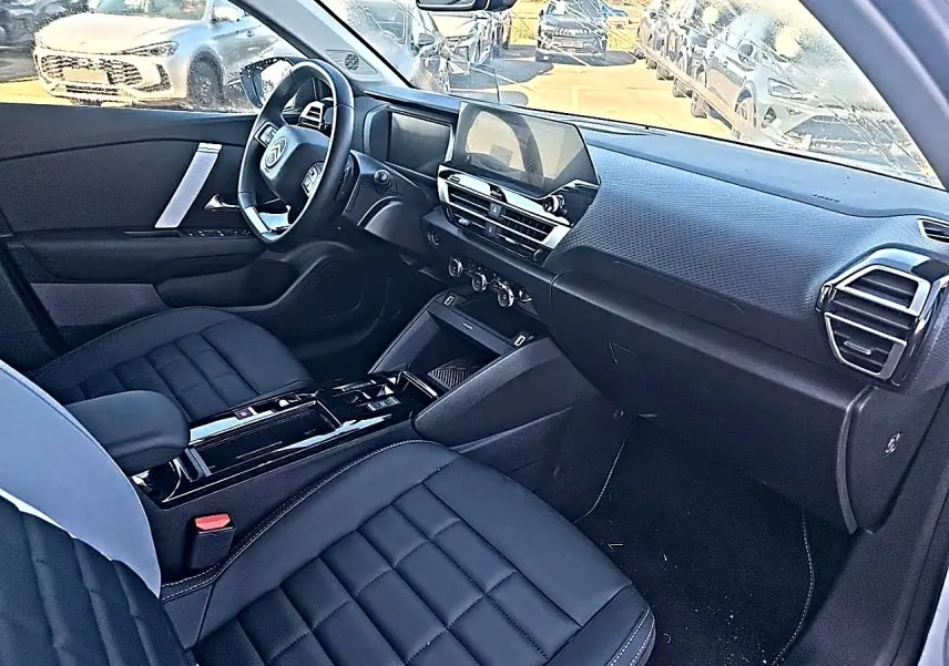 Vue intérieure côté conducteur de la Citroën C4 X 2025, montrant sièges noirs et tableau de bord moderne avec écran tactile.