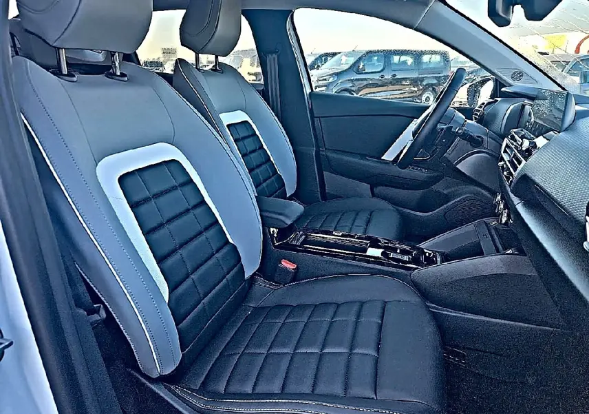 Vue intérieure côté droit des sièges avant noirs et gris du Citroën C4 X 2025 avec console centrale moderne.