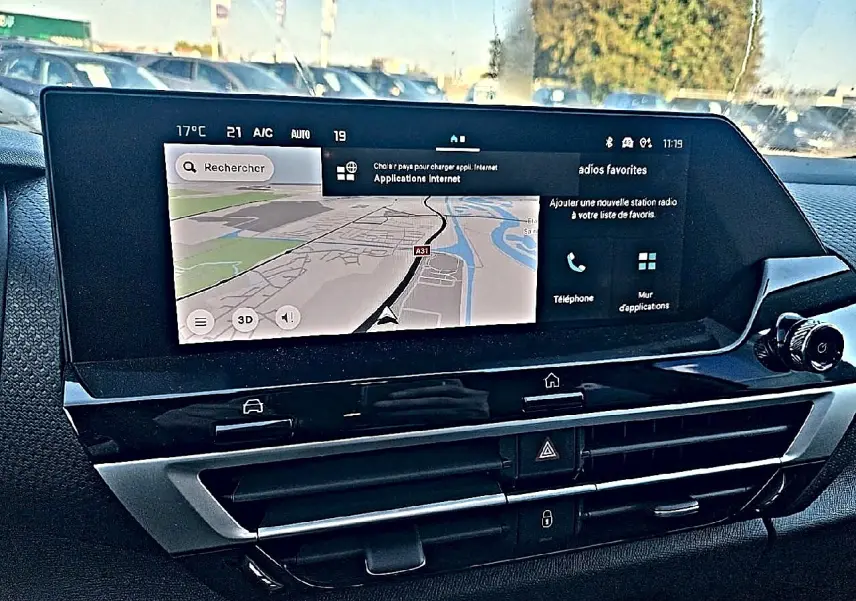 Écran tactile central avec navigation GPS dans l'habitacle du Citroën C4 X hybride blanc, vue de face rapprochée.