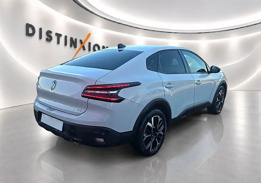 Vue 3/4 arrière droite d'une Citroën C4 X blanche 2025 avec feux arrière LED et jantes alliage noires.