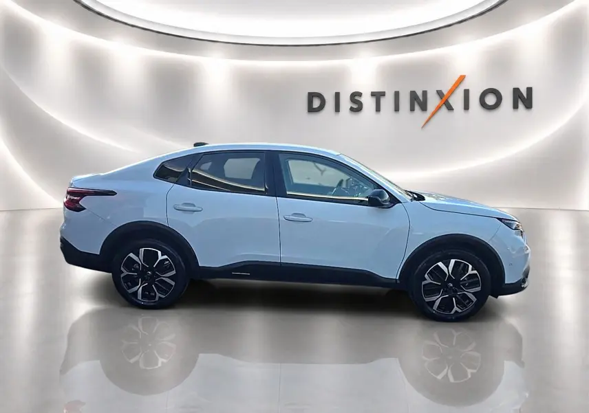 Vue latérale droite d'une Citroën C4 X blanche avec jantes alliage noires et détails noirs sur bas de caisse.