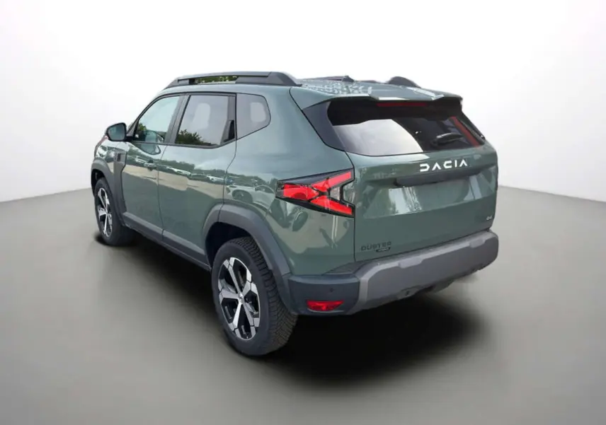 Vue 3/4 arrière droite du Dacia Duster 2026 hybride en kaki lichen avec jantes alu 18 pouces et barres de toit.