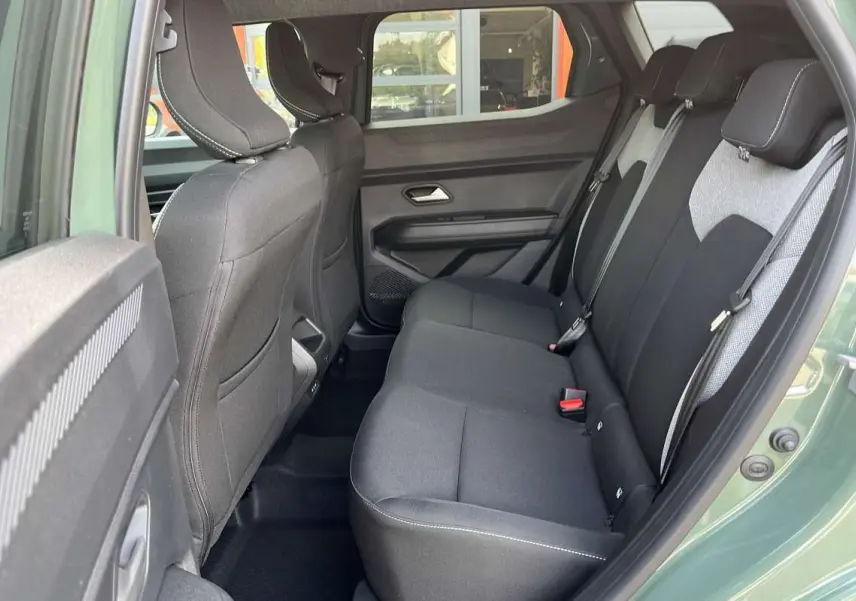 Vue intérieure côté droit sur la banquette arrière noire et grise du Dacia Duster Hybrid-G 150 4x4 couleur kaki lichen.