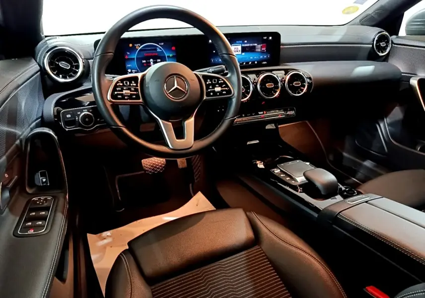 Vue intérieure côté conducteur de la Mercedes CLA 180 d 2021, tableau de bord digital et volant cuir multifonctions.