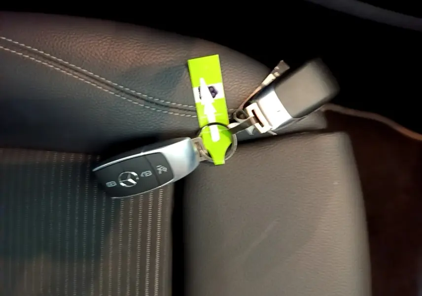 Gros plan sur clé Mercedes posée sur siège en cuir noir avec surpiqûres blanches, intérieur CLA 180 d Business Line.