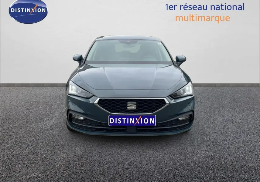 Vue frontale d'une SEAT Leon 2025 gris magnétique métallisé avec calandre hexagonale et phares LED allumés.