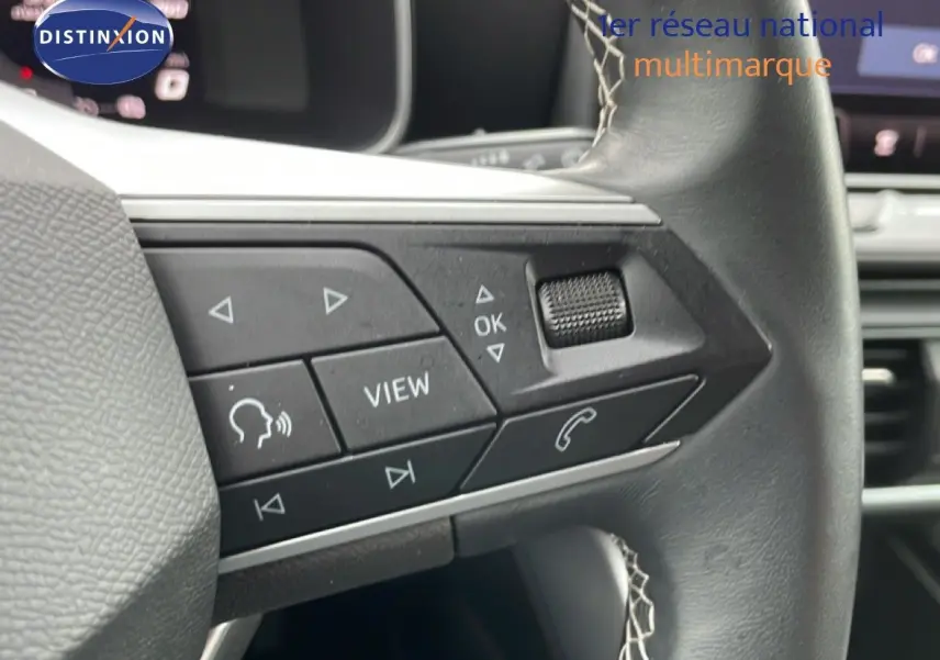 Gros plan sur les commandes gauche du volant en cuir noir du SEAT LEON 2.0 TDI 115CH STYLE XL 2025.