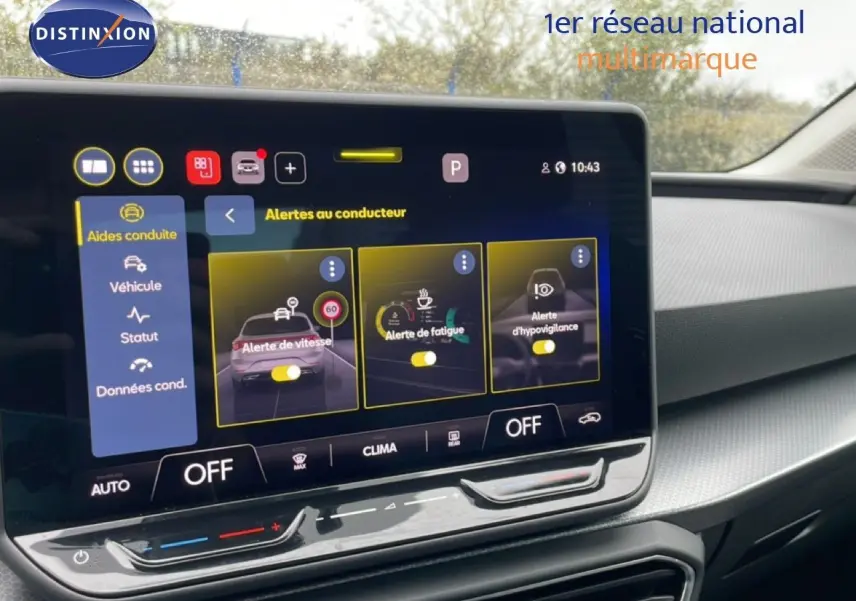 Écran tactile central affichant les alertes au conducteur dans l’habitacle d’une SEAT LEON gris magnétique, vue de face.