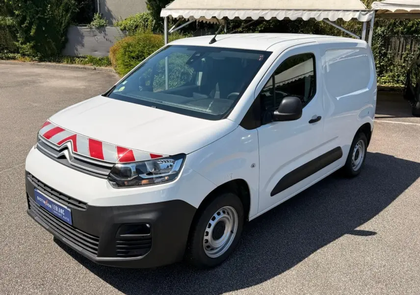 Vue 3/4 avant droit d’un Citroën Berlingo Van blanc 2020 avec marquage rouge et blanc sur le capot et protections noires.