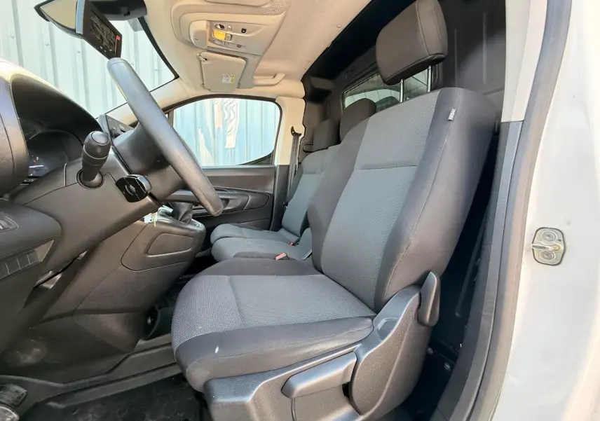 Vue intérieure côté conducteur du Citroën Berlingo Van blanc 2020, sièges tissu gris et tableau de bord noir.