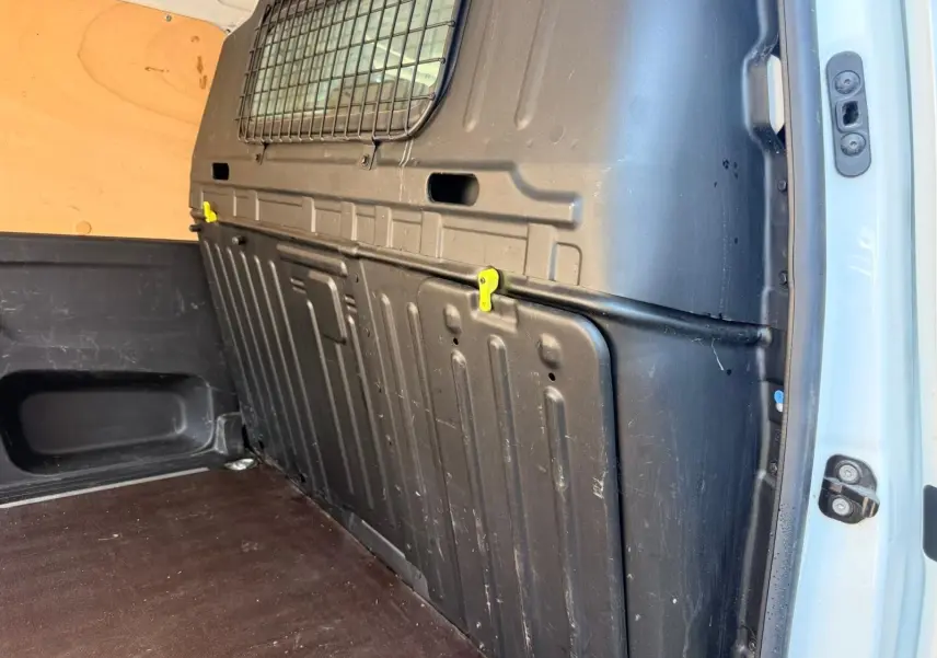 Vue intérieure arrière droite du Citroën Berlingo blanc 2020, montrant la cloison de séparation noire et le plancher en bois.