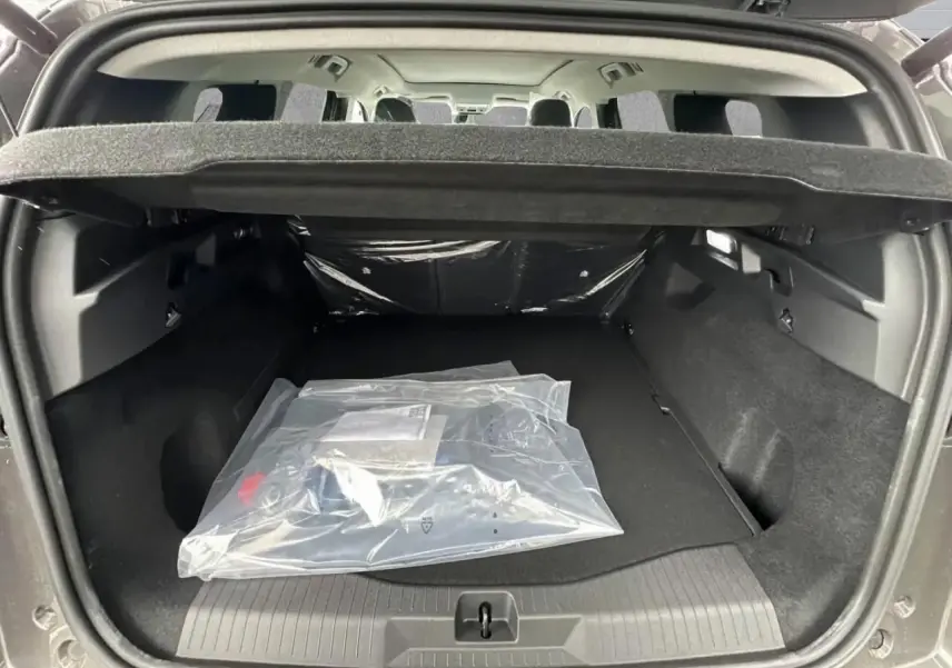 Coffre ouvert d’un Citroën C5 Aircross gris platinium, vue arrière montrant l’espace de chargement vide avec couverture de coffre.