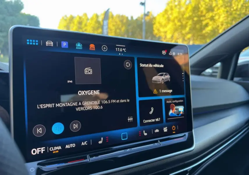 Écran tactile central intérieur de Volkswagen Golf gris argent, affichant radio et statut véhicule.