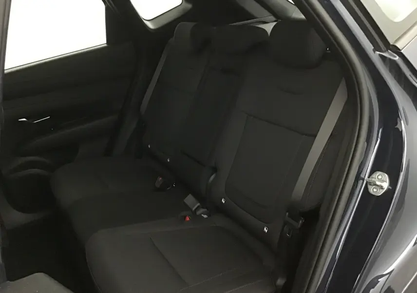 Vue intérieure sur les sièges arrière noirs du Hyundai Tucson 2025 bleu Salling, avec portière droite ouverte.