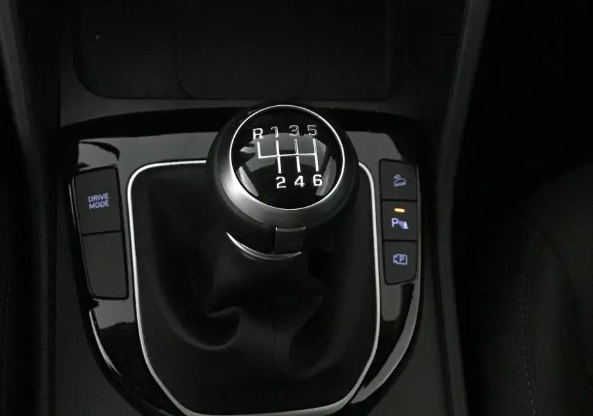 Le levier de vitesse manuel du Hyundai Tucson 2025, entouré de commandes de mode de conduite et d'assistance au stationnement.