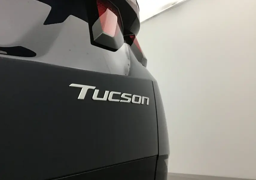 Gros plan sur l'arrière droit du Hyundai Tucson bleu Salling, mettant en valeur le logo et le feu arrière.
