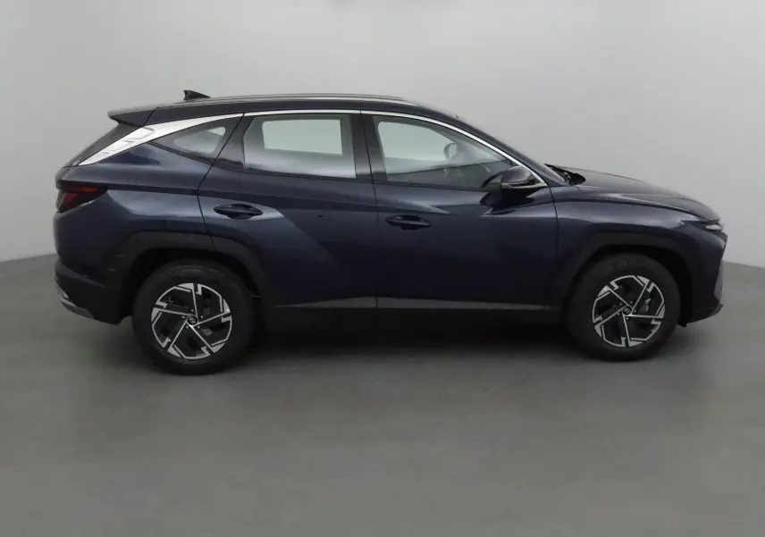 Profil côté gauche du Hyundai Tucson 2025 bleu Salling, soulignant ses lignes modernes et ses jantes alliage noires.