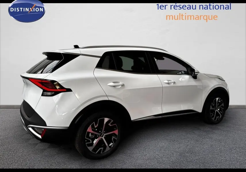 Vue 3/4 arrière droite d’un KIA SPORTAGE blanc nacré métal avec jantes noires et toit noir contrasté.