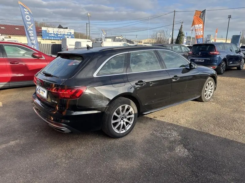Audi A4 Avant noir brillant vue 3/4 arrière droit, avec jantes alu et feux arrière LED distinctifs.