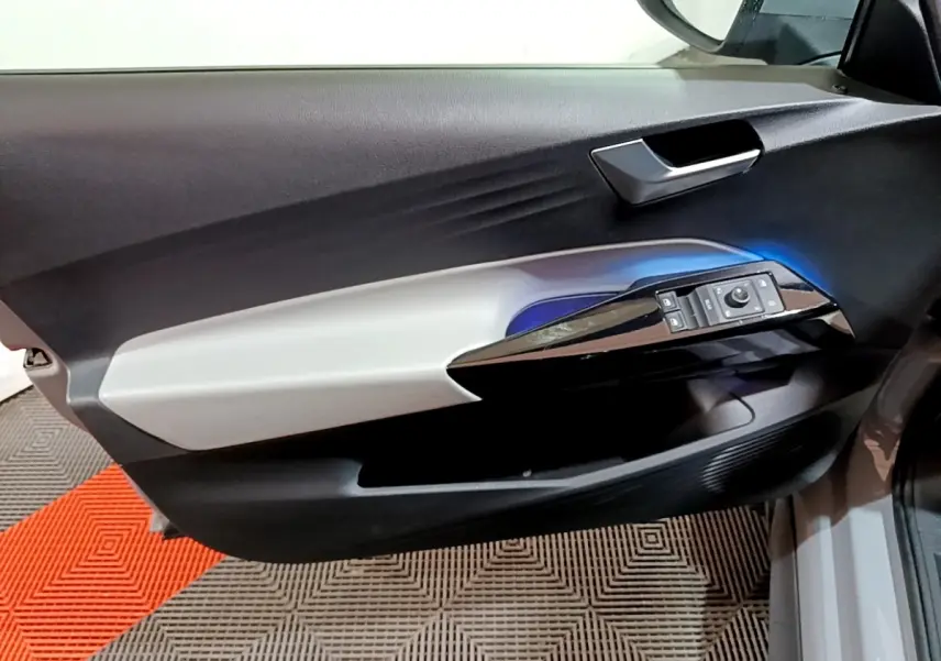Vue rapprochée de la porte côté conducteur du Volkswagen ID.3 77 kWh Pro S gris foncé, avec commandes électriques et éclairage bleu.