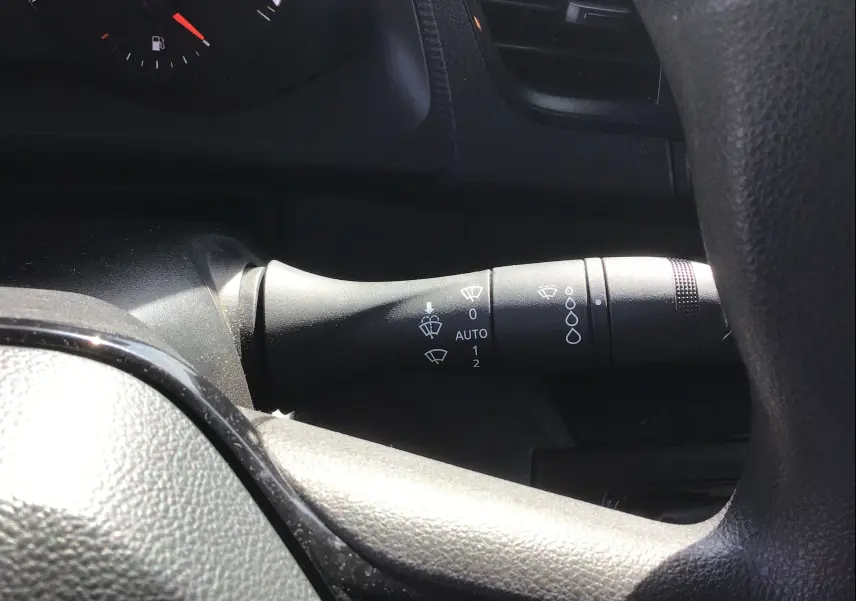 Gros plan sur la commande d’essuie-glace à droite du volant du Renault Kangoo blanc 2024, intérieur noir.