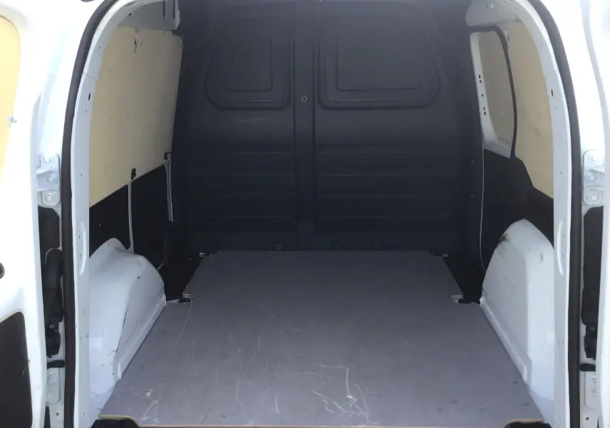 Vue intérieure arrière du Renault Kangoo Van blanc 2024, montrant l’espace de chargement vide avec parois latérales protégées.