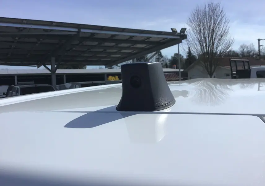 Gros plan sur la caméra de recul noire installée sur le toit blanc du Renault Kangoo Van 2024, vue de dessus.