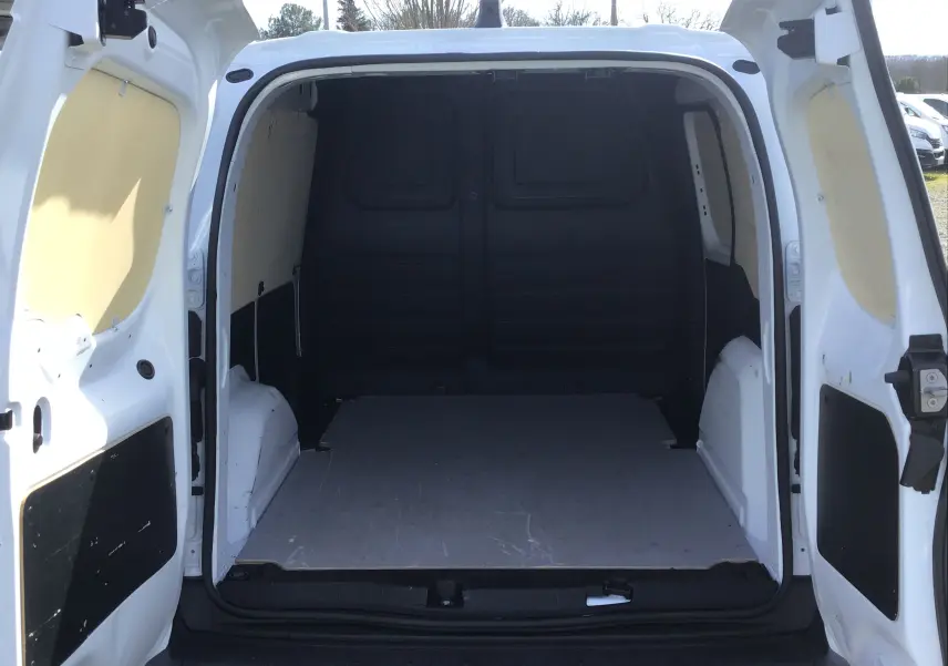 Vue arrière ouverte du Renault Kangoo Van blanc 2024, montrant l'espace de chargement vide et les portes battantes ouvertes.