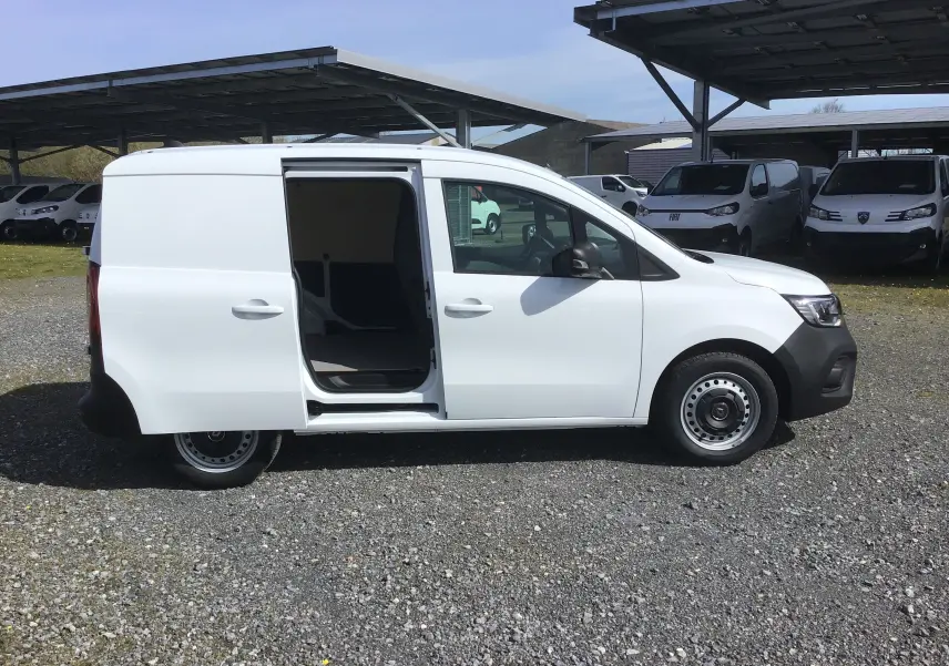 Vue de profil côté gauche du Renault Kangoo blanc 2024 avec porte latérale coulissante ouverte sur parking extérieur.