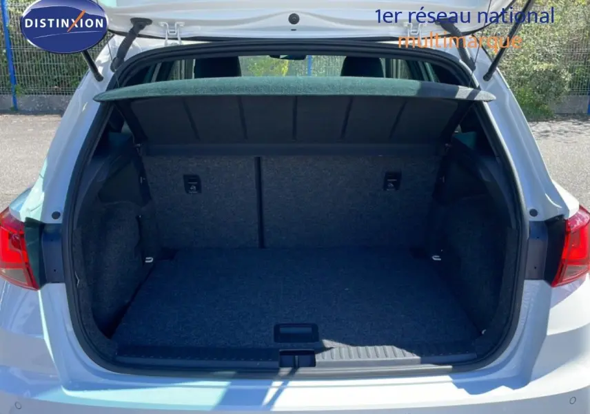 Coffre ouvert vu de l'arrière d'un SEAT Arona blanc à toit noir, montrant l'espace de chargement vide.
