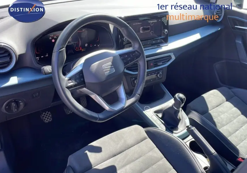 Vue intérieure avant du SEAT Arona 2025 avec volant cuir, boîte manuelle et sièges alcantara noirs.