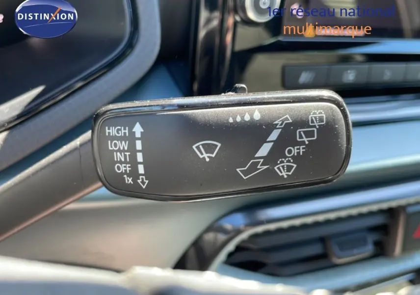 Gros plan sur la commande d’essuie-glace dans l’habitacle d’une SEAT Arona blanc toit noir, avec tableau de bord en arrière-plan.